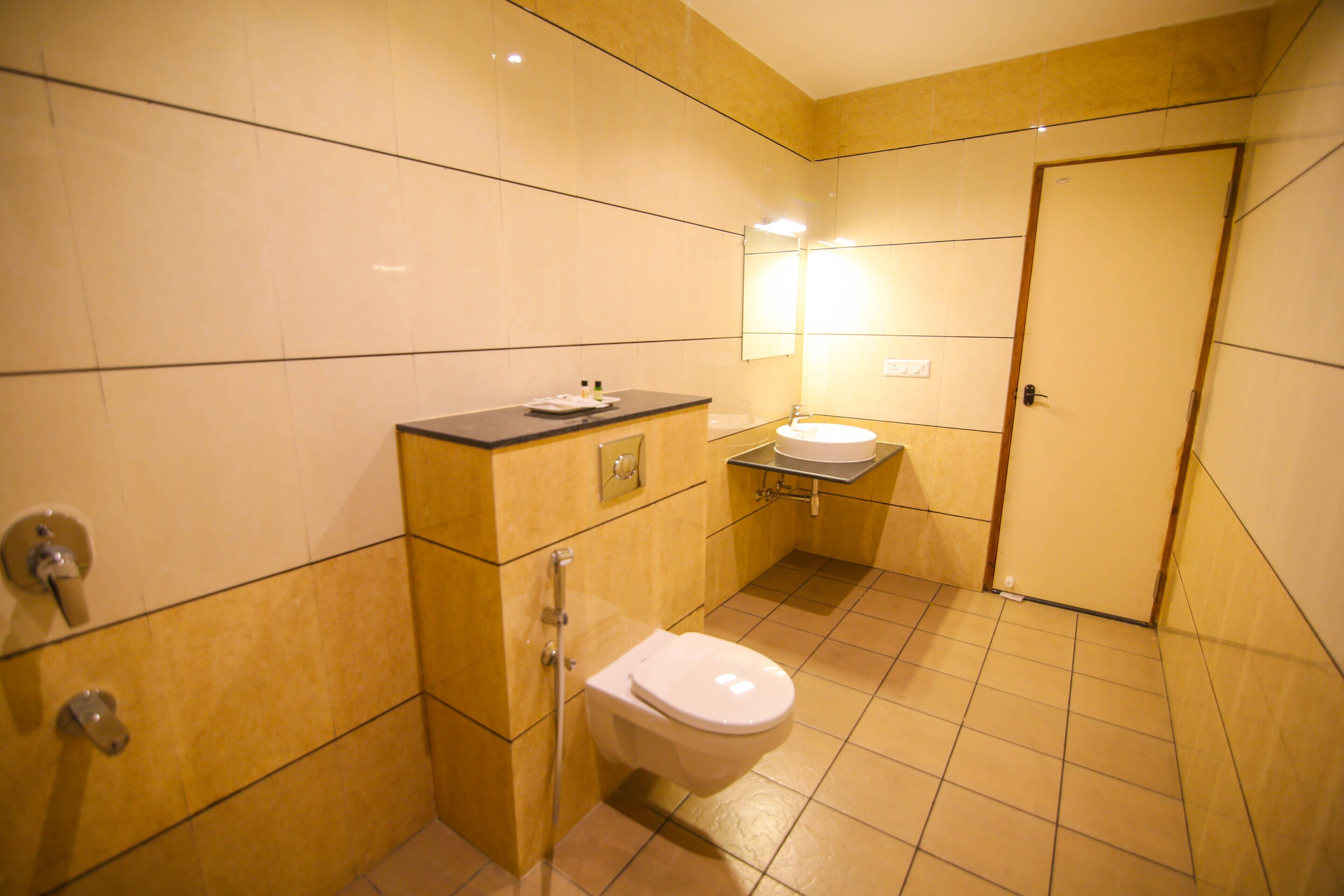 A small bathroom with a toilet, sink, and mirror.
