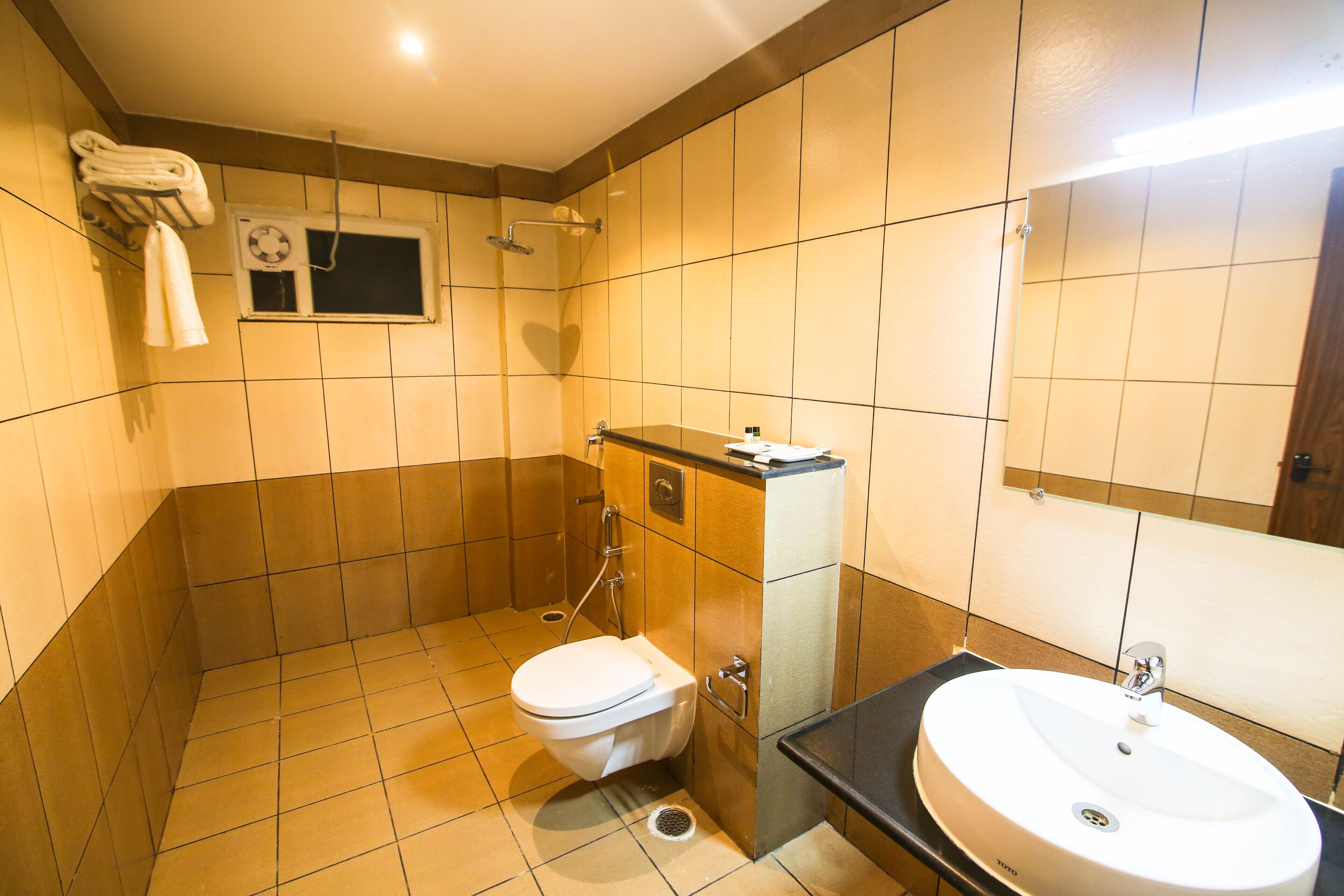 A bathroom with a toilet, sink, and shower.