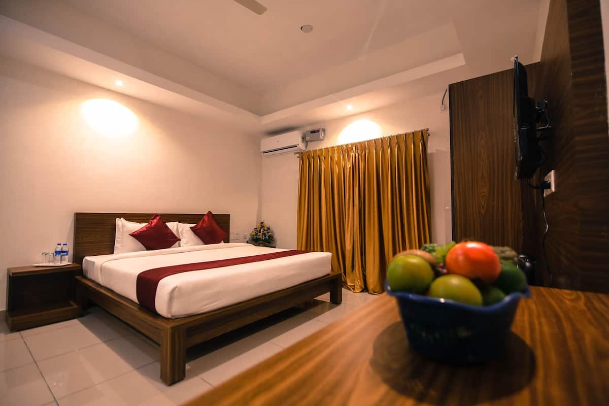 A hotel room with a bed, bedside table, and a fruit bowl.