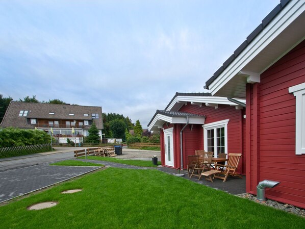 A red building with a patio area and outdoor seating.