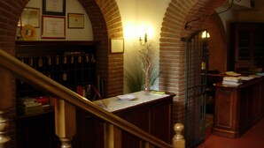 A library with brick arches, bookshelves, and framed certificates on the walls. - La Caveja (Pietravairano)