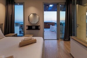 A bedroom with a large bed, a mirror, and a view of the sea through the sliding glass doors. - Napa Hills Seaview Villas (Ayia Napa)