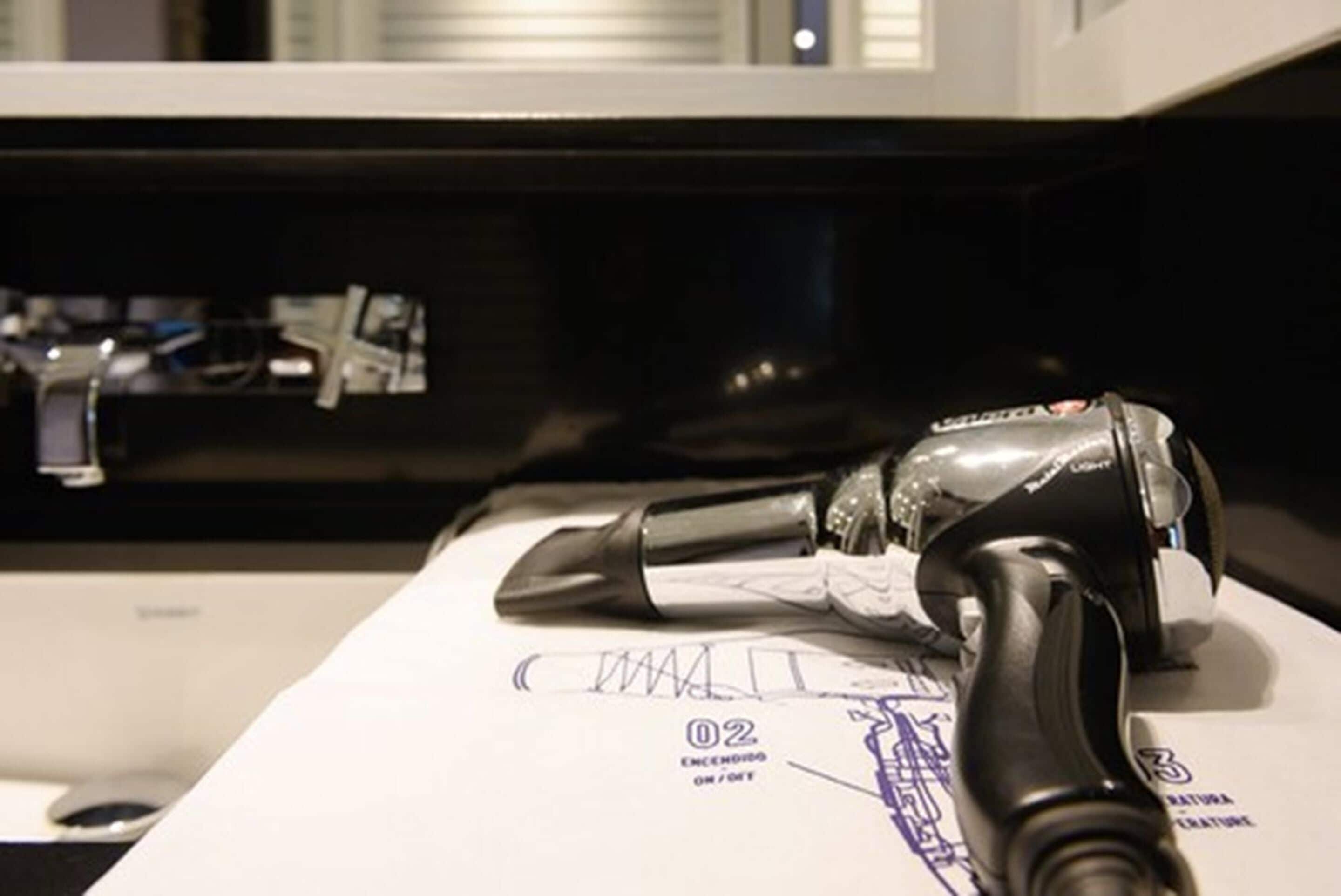 A vacuum cleaner on a white surface with a document underneath.