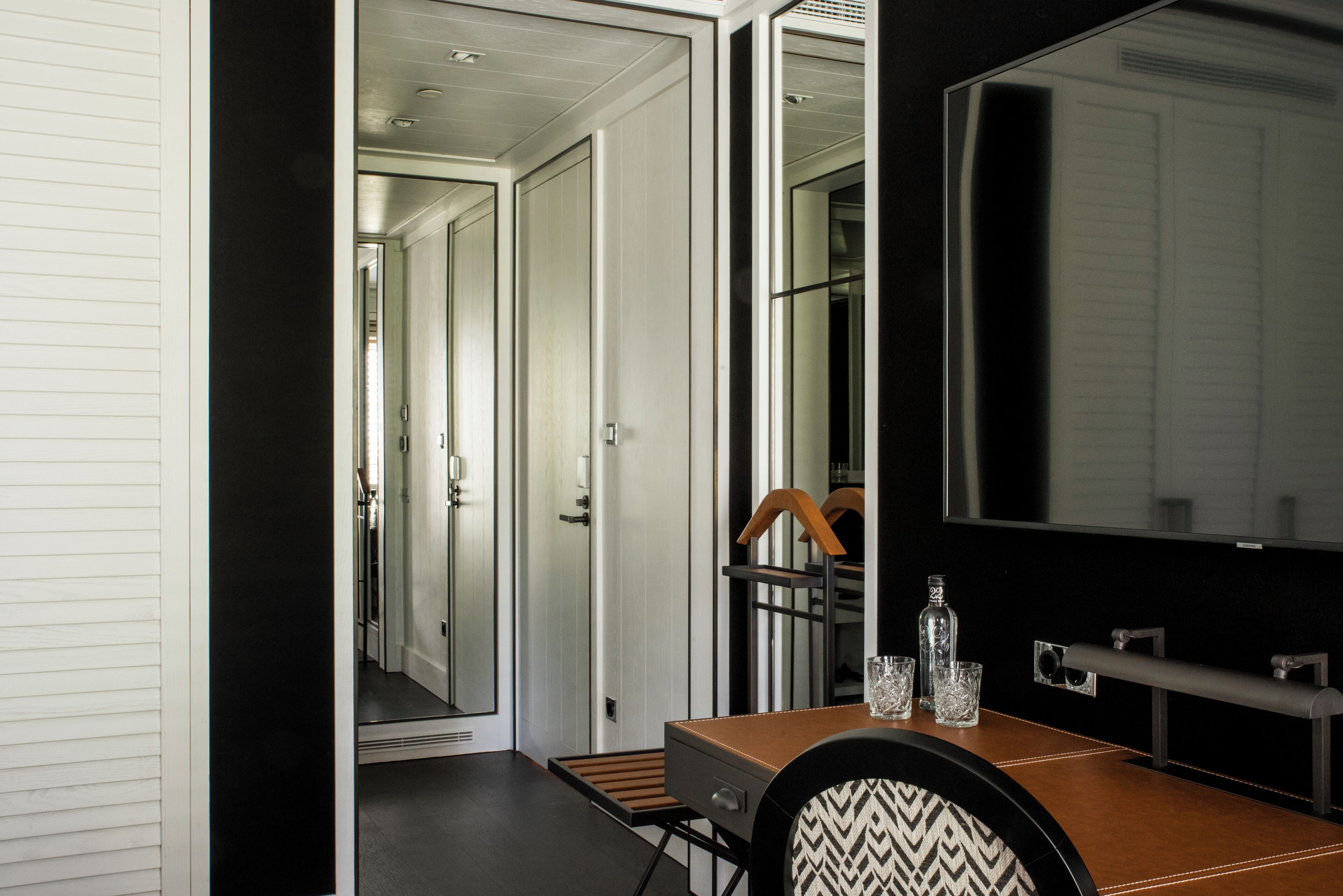 A modern bathroom with a large mirror, a wooden vanity, and a shower area.