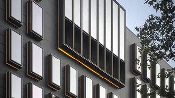 Un edificio moderno con una serie de ventanas rectangulares alineadas en un patrón de cuadrícula.