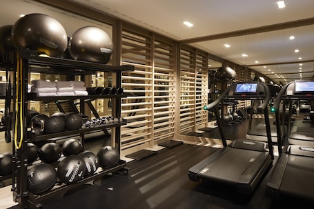 A gym with treadmills, exercise balls, and weights.