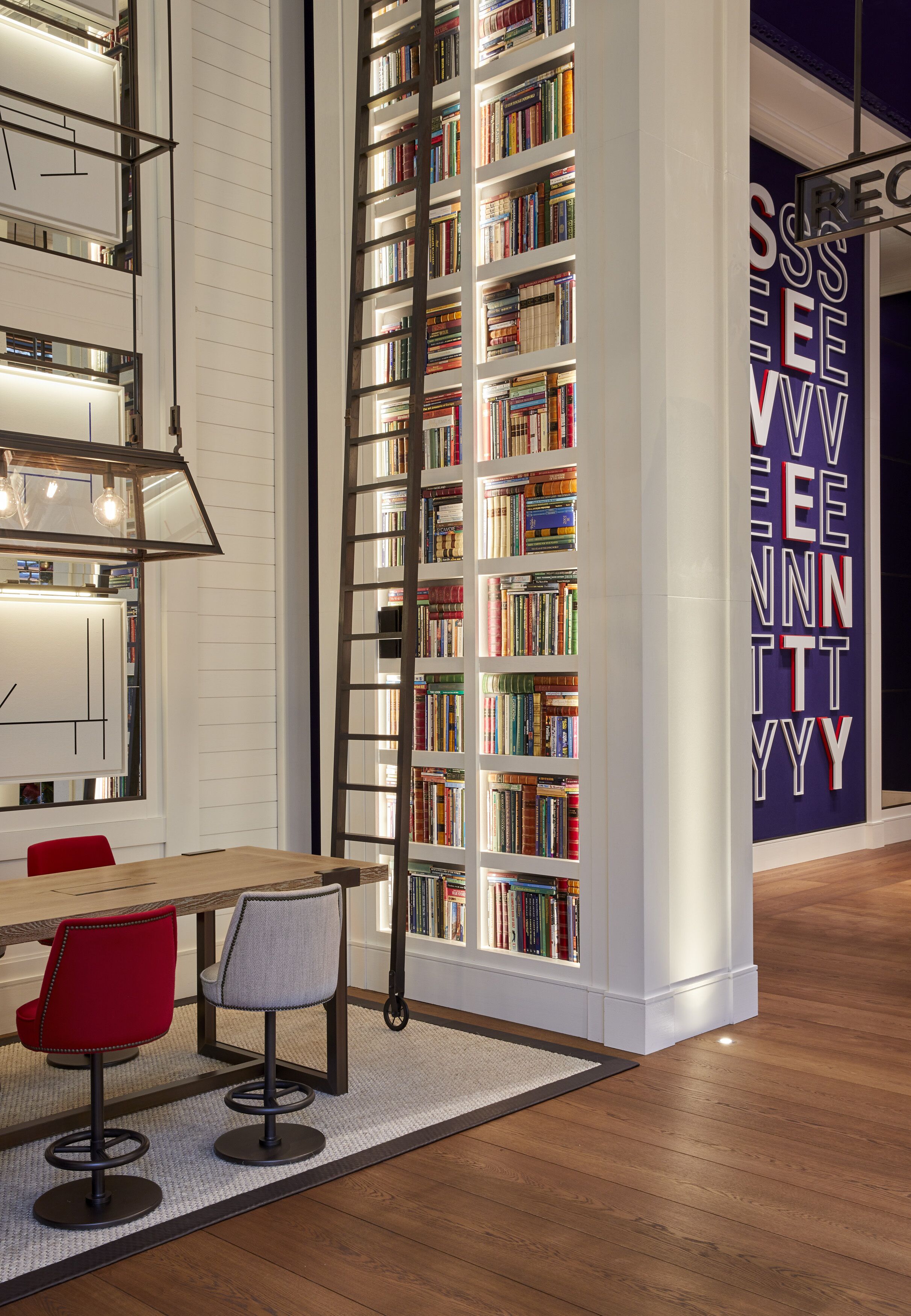 Una biblioteca moderna con estanterías, una mesa y dos sillas.