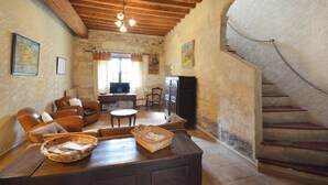 A rustic living room with wooden furniture, a fireplace, and a stone wall. - Homerez - House near Saintes-Maries-de-la-Mer (Saintes-Maries-de-la-Mer)