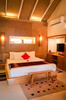 A hotel room with a bed, bedside table, and a mirror.