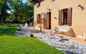 A house with a patio area, outdoor seating, and a garden. - Homerez - Festive House in Callen (Callen)