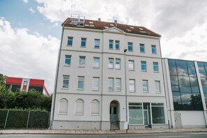 A multi-story building with a symmetrical facade, large windows, and a central entrance with steps. - Limehome Chemnitz Hartmannstraße (Chemnitz)