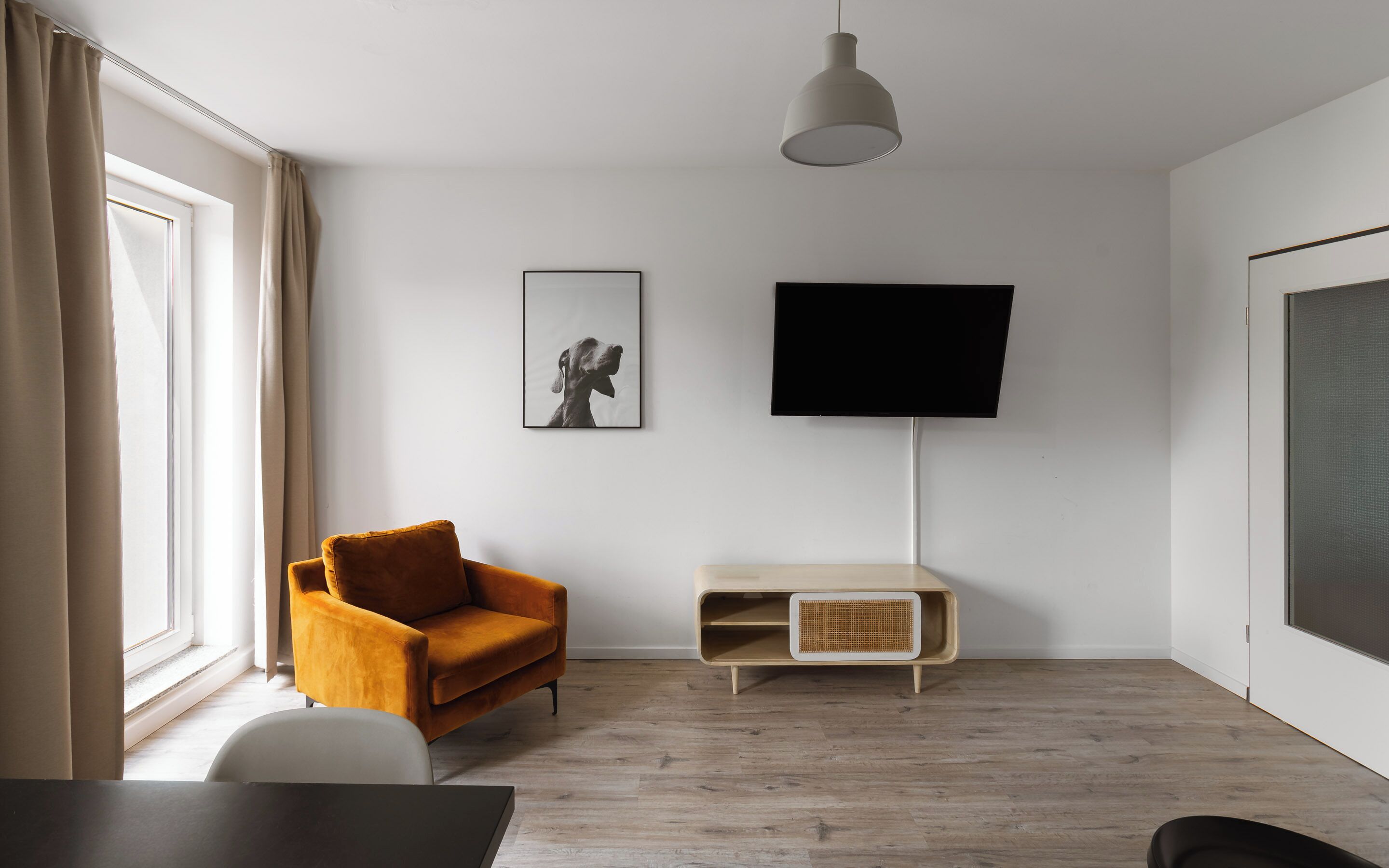 Una sala de estar moderna con un sofá, un televisor de pantalla plana y un cuadro en la pared.