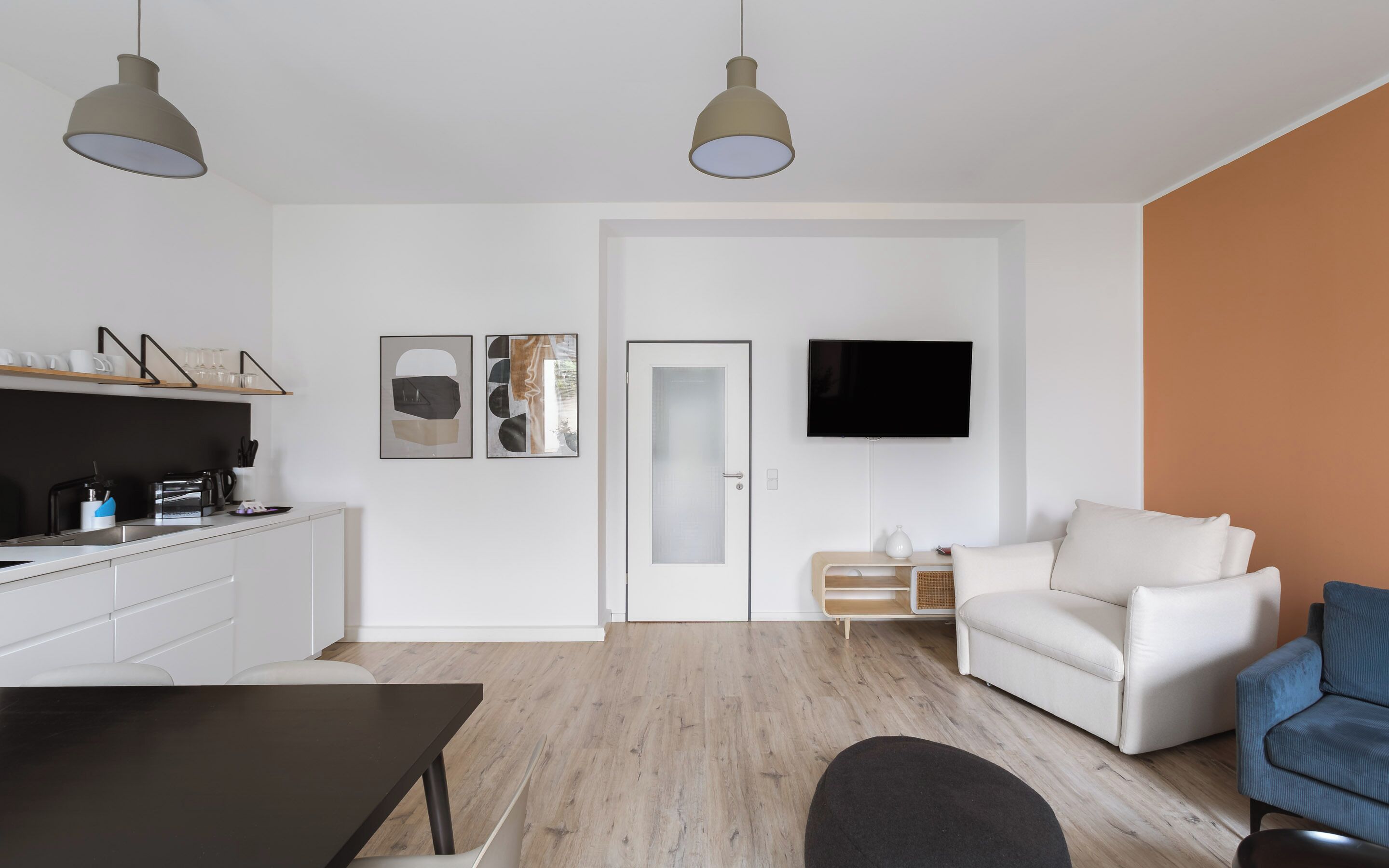 A modern living space with a kitchen, dining area, and seating area.
