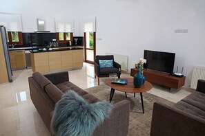 A modern living room with a sofa, a coffee table, and a TV.