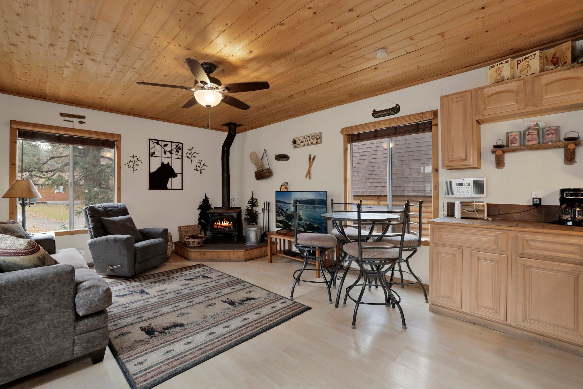 Una sala de estar acogedora con chimenea, comedor y armarios de madera.