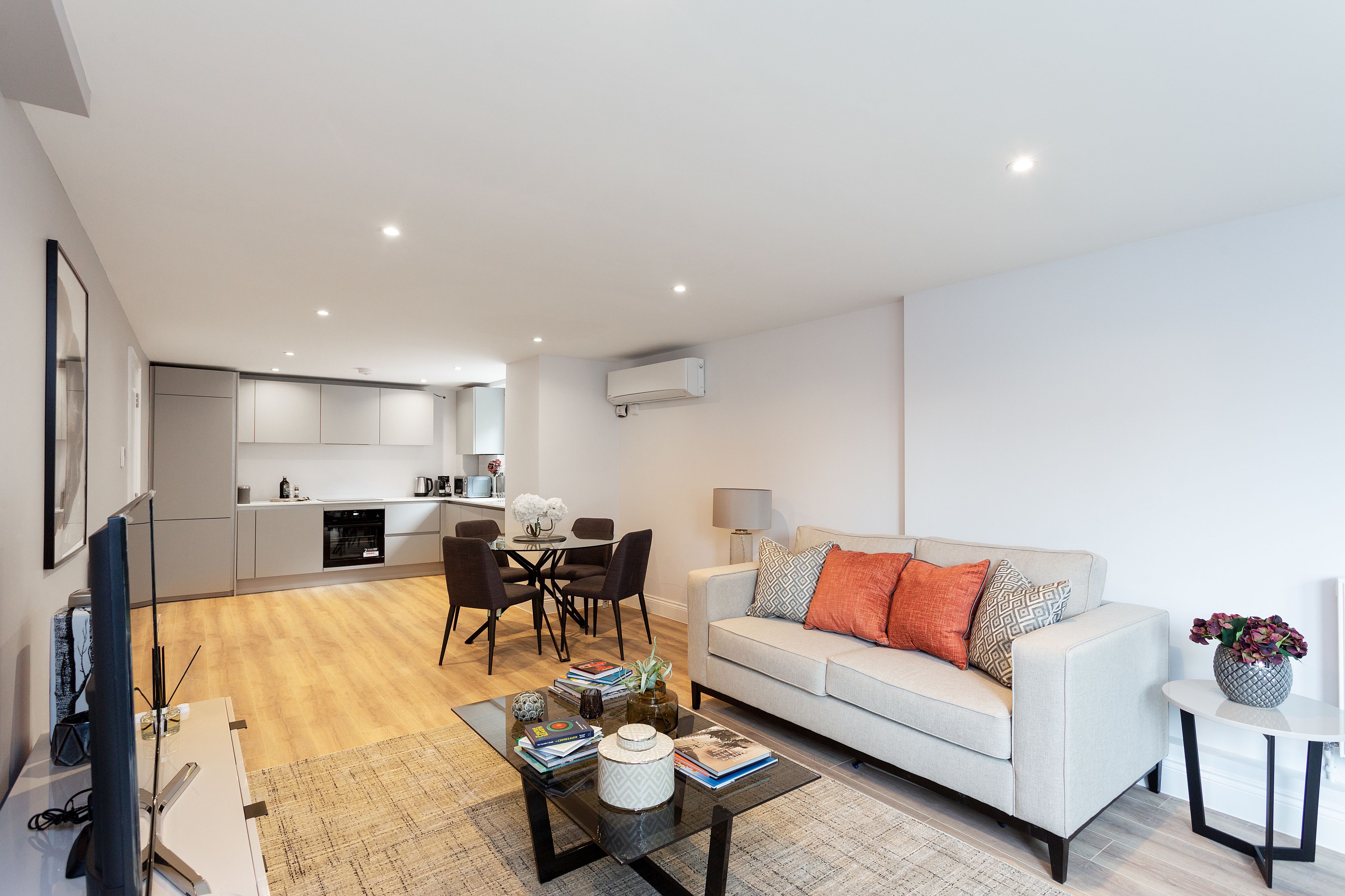 A modern living room with a sofa, coffee table, and dining area.