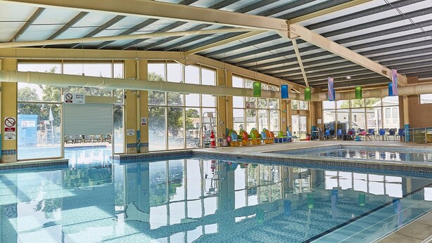 An indoor swimming pool with clear water, a tiled floor, and a roof structure. - Highfield Grange Holiday Park
3 Bed Sleeps 8
 (Clacton-on-Sea)