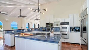 A spacious kitchen with a large island, white cabinetry, and modern appliances. - Joie de Vivre (4 bedrooms) - Beachfront Baie Rouge villa with pool, Terres Basses, St. Martin (Les Terres Basses)