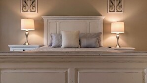 A bedroom with a white headboard, two bedside lamps, and decorative wall sconces. - FAMILY RETREAT/ PET FRIENDLY NEAR MILITARY BEACHES AND BASES (Jacksonville)