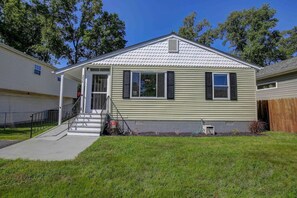 A single-story house with a front porch, a small front yard, and a visible garage door.