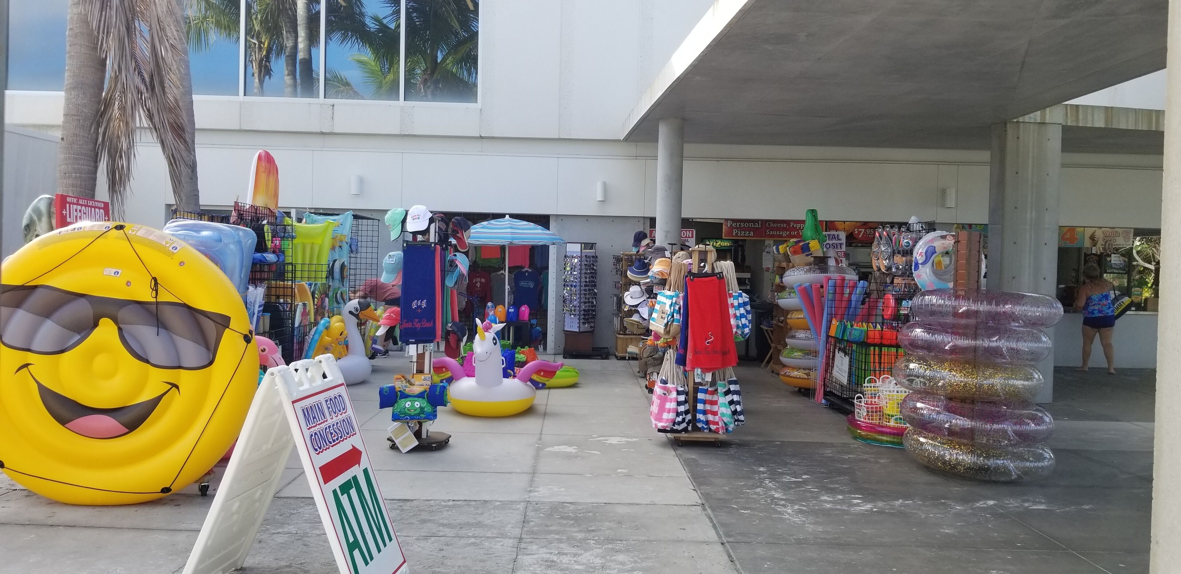 Ein Markt im Strandthema im Freien, mit aufblasbaren Spielzeugen, einem Rettungsschwimmer-Schild und einem 7-Eleven-Kiosk.