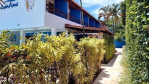 A modern hotel with a white facade, multiple balconies, and lush tropical landscaping. - Pousada Lua Azul (Ipojuca)