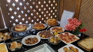 A buffet with various dishes including pastries, meats, and vegetables. - Pousada Lua Azul (Ipojuca)