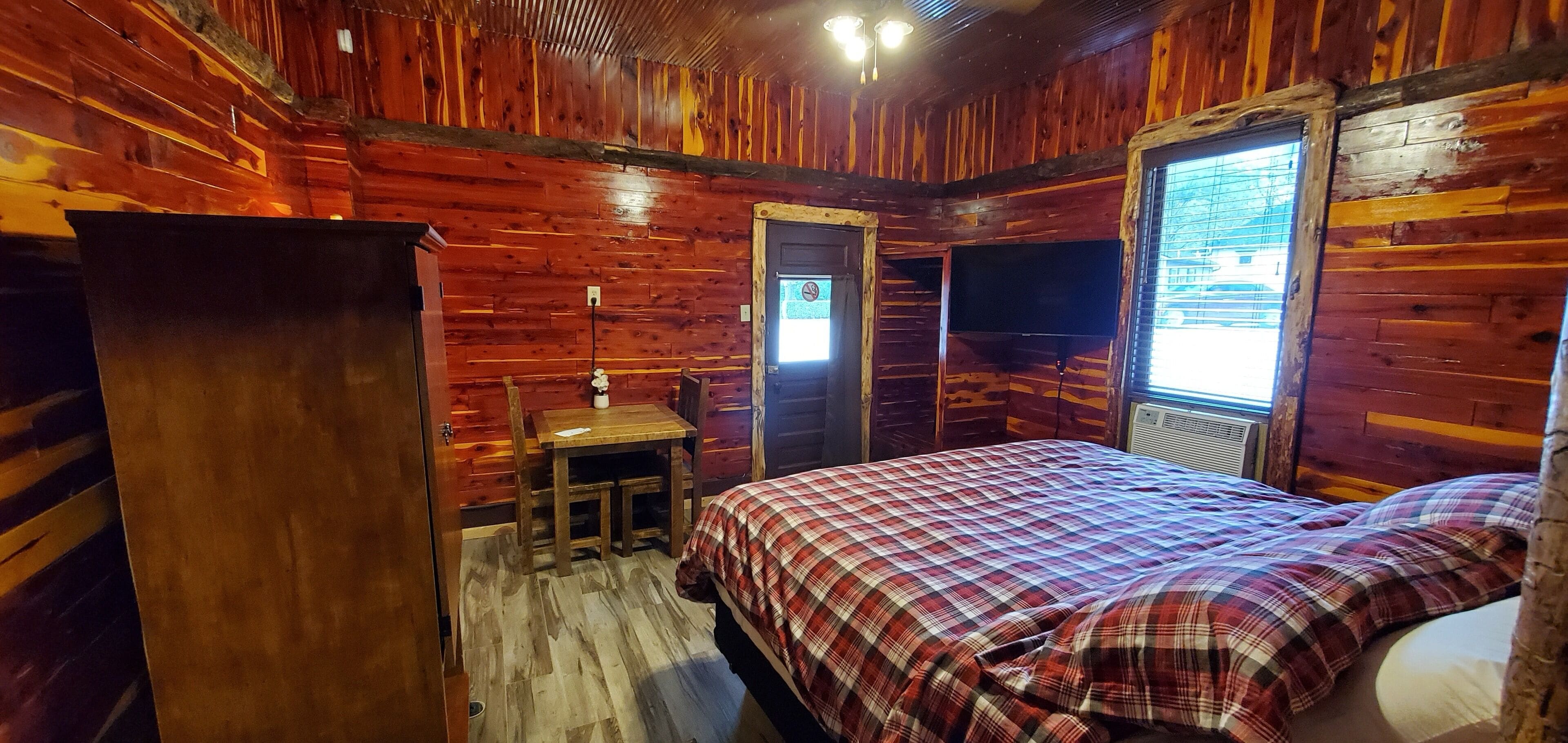 Une pièce aménagée comme un chalet en bois, avec un lit, un bureau et une chaise.
