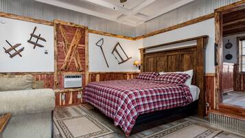 Quarto com cabeceira de madeira, colcha xadrez, um banco de madeira e decoração rústica na parede.