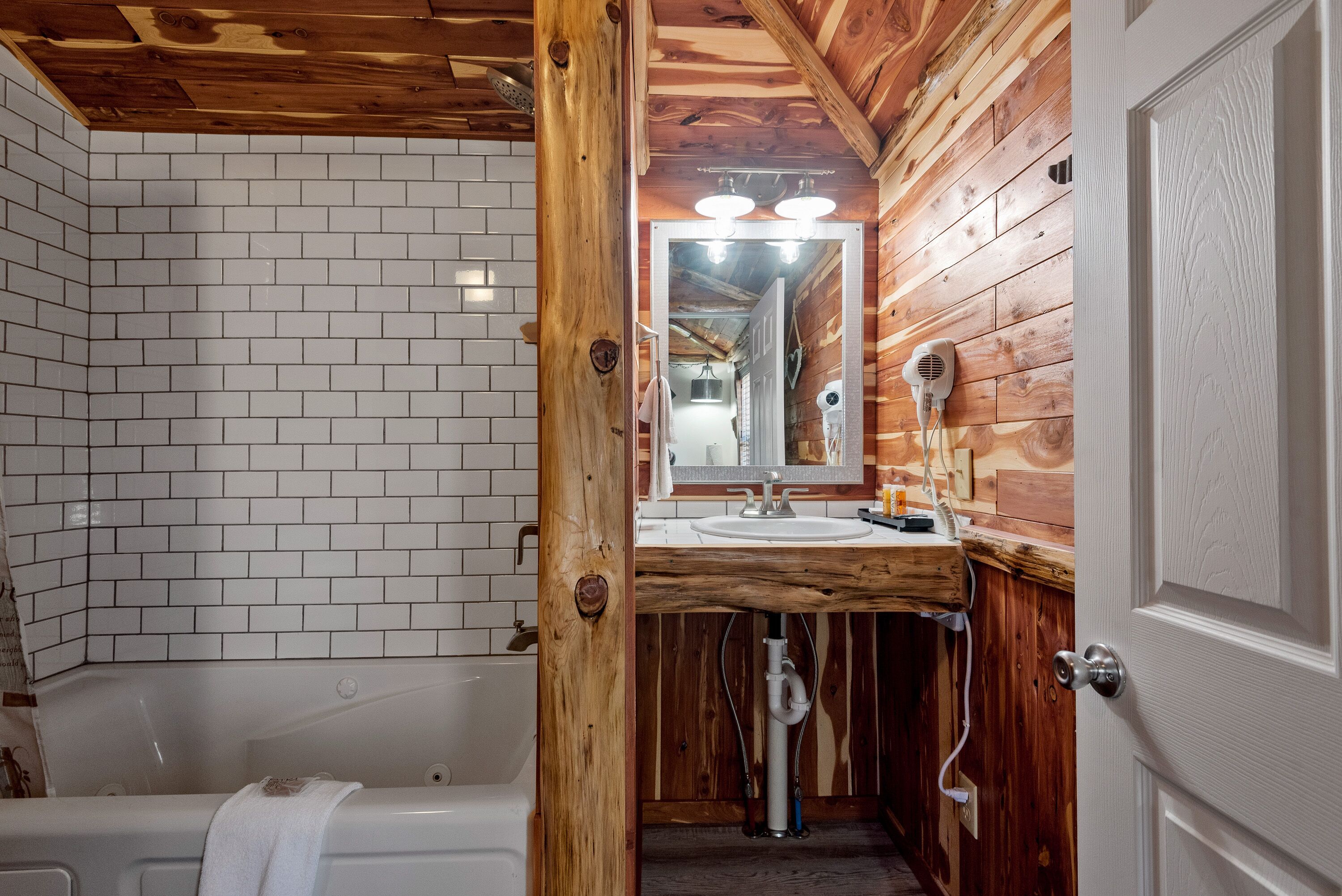 Une salle de bain avec un meuble-lavabo en bois, un lavabo blanc et un grand miroir.