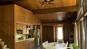 A spacious kitchen with wooden cabinets and a dining area with wicker chairs and a round table. - Lake Michigan is only a short 1 minute walk away! (Macatawa)