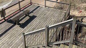 A wooden boardwalk leading to a beach with a railing and benches. - Lake Michigan is only a short 1 minute walk away! (Macatawa)