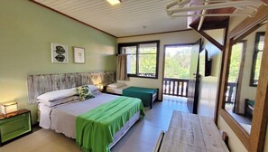 A bedroom with two beds, a wooden headboard, a green bedspread, and a view of the outdoors through a window. - Pousada da Ferrugem (Garopaba)