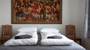 A bed with two pillows, a large tapestry above it, and two wooden chairs. - The Holiday House ÁSAR - Amazing View (Kirkjubæjarklaustur)