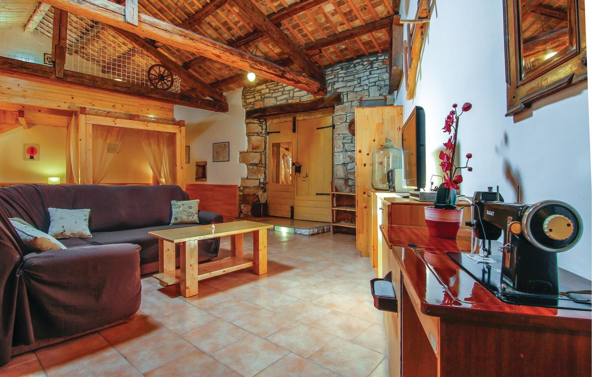 A cozy living room with a wooden sofa, a coffee table, and a stone fireplace.
