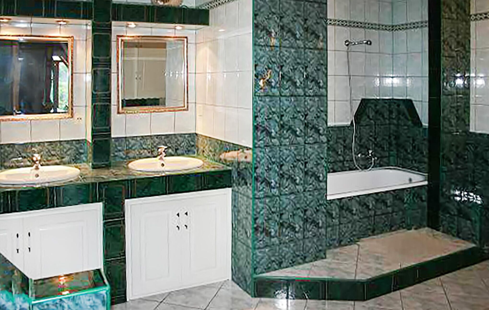 A bathroom with two sinks, a bathtub, and a shower.