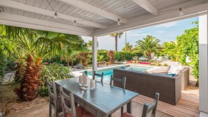 A covered outdoor area with a pool, wicker furniture, and tropical plants. - Luxurious home in Medulin with private swimming pool, can be inside or outside (Medulin)