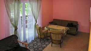 A room with a dining table, chairs, a sofa, and a patterned rug. - Nice home in Gietrzwald (Gietrzwald)