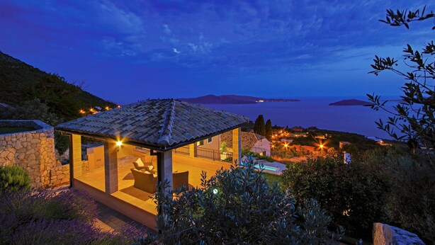 A secluded villa with a stone exterior, a covered outdoor seating area, and a view of the sea. - Awesome home in Trsteno with sauna (Trsteno)