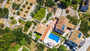 An aerial view of a residential area with a swimming pool, terracotta-roofed houses, and surrounding greenery. - Awesome home in Trsteno with sauna (Trsteno)