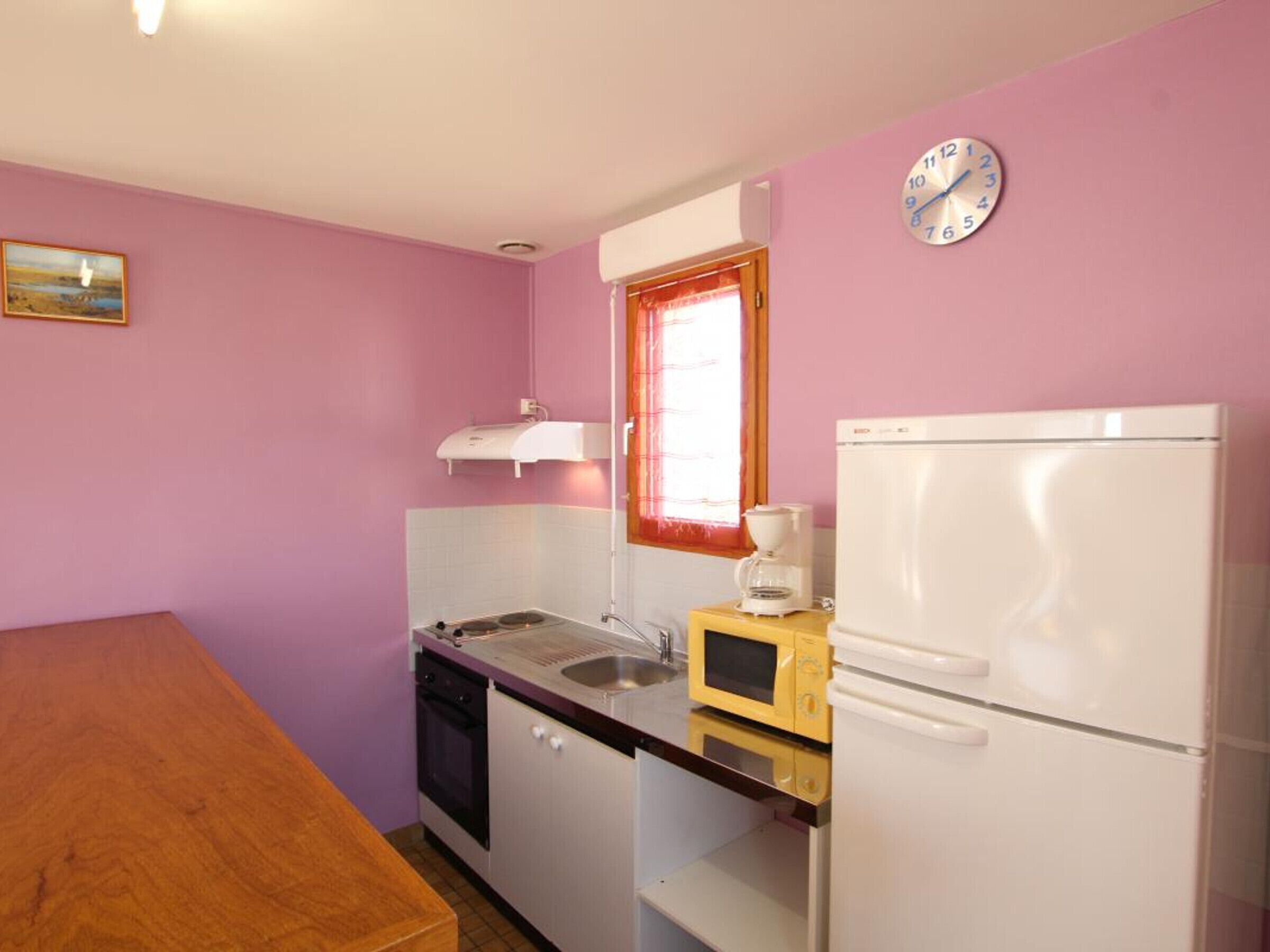 A compact kitchen with a sink, microwave, and refrigerator.