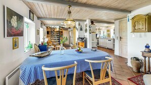 A dining area with a checkered tablecloth, wooden chairs, and a chandelier. - Amazing home in Haderslev (Haderslev)