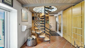 A spiral staircase in a room with tiled flooring, a white radiator, and a yellow wardrobe. - Amazing home in Haderslev (Haderslev)