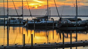 A marina with several boats docked, a wooden dock, and a sunset in the background. - Amazing home in Haderslev (Haderslev)