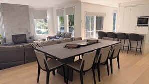 A modern kitchen with white cabinets, a built-in oven, and a dining area with a large table and chairs. - THE LODGE - TENNIS,LGE SPA,WOOD FIRE, (Anglesea)