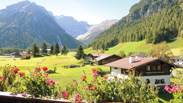 A mountain village with traditional houses, green fields, and a valley. - Ferienwohnung in Obernberg (Obernberg)