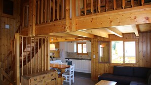 Ein Holzblockhaus mit Essbereich, Küche und Wohnbereich.