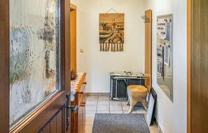Enter a cozy space with a comfortable bed, a small table, and a bulletin board.