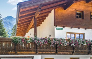 Traditional chalet-style building with a balcony and wooden gable roof, offering a cozy lodging experience.