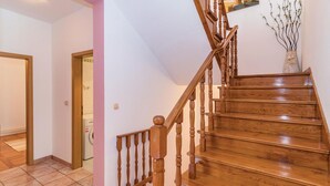 Eine Holztreppe mit Handlauf, die zu einer oberen Etage führt.